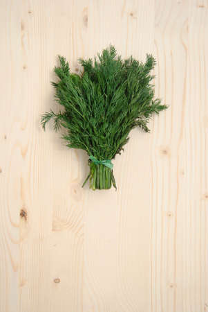 Fresh dill on wood texture background. Above view.の写真素材