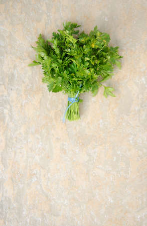 Bunch of ripe parsley on warm stone textured background. Above view.の写真素材