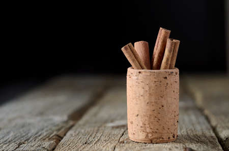 Cinnamon sticks on dark wood table. Shallow depth of field.