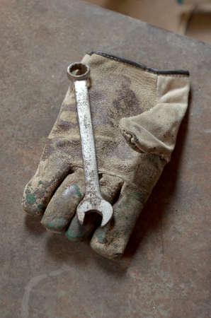 Rusty hand wrench tool and gloves on rusty metal background. Above view.の写真素材