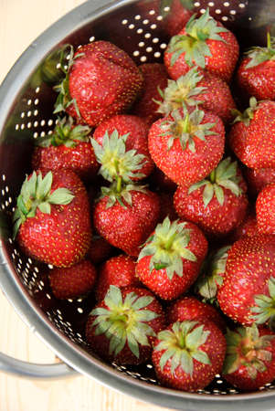 Fresh bowl of strawberries on wood background. Above view.の写真素材