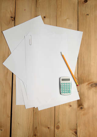 Calculator, pencils and blank paper on wood background. Above view.の写真素材