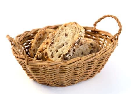 Slices of grain bread in basket isolated on white background