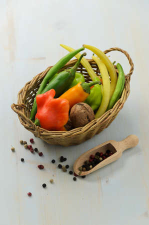 Peppers, walnut and green beans in basket on wooden backgroundの写真素材