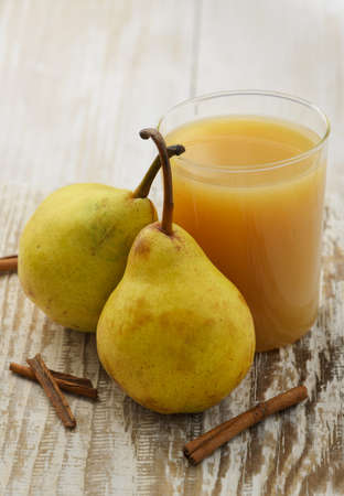 Ripe pears and juice on white wood backgroundの写真素材