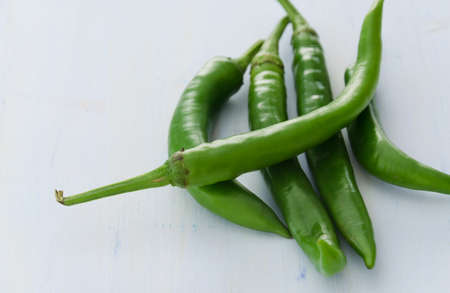 Green peppers on light blue wooden backgroundの写真素材