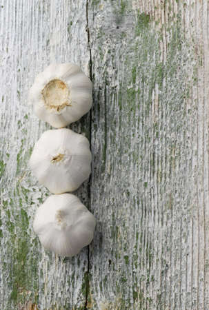 Cloves of garlic over old textured wooden backgroundの写真素材