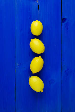 Lemons over blue wooden background. Above view
