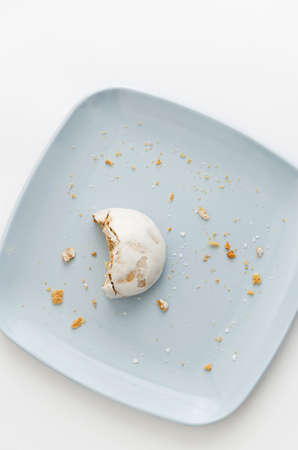 Half of gingerbread cookie on blue plate over white background