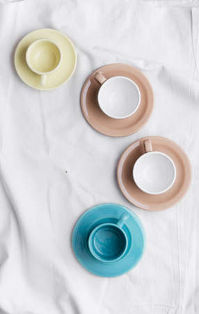 Collection of cups over white cloth. Overhead viewの写真素材