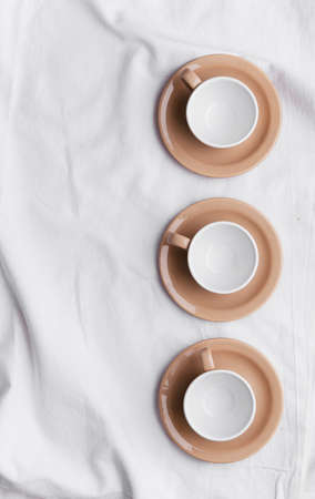 Collection of brown cups over white cloth. Above viewの写真素材