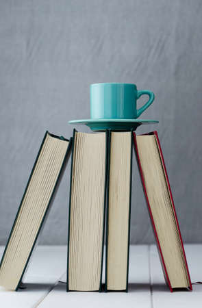 Blue coffee cup on top of four booksの写真素材