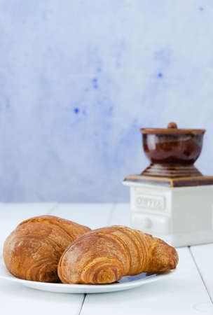 Two croissant on white plate over wooden tabel with copy spaceの写真素材