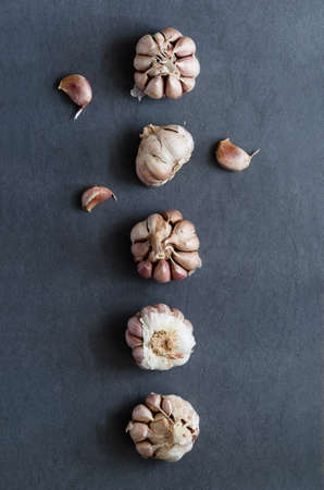Cloves of garlic aligned in a row over dark blue table, above viewの写真素材