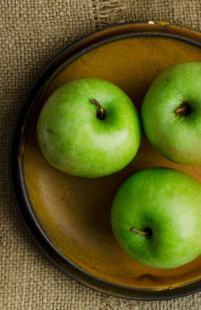 Close up of green apples over burlap, above viewの写真素材