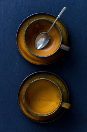 Two empty cups over dark blue cloth, above viewの写真素材
