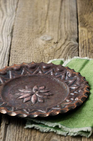 Old vintage copper plate over rustic wooden table