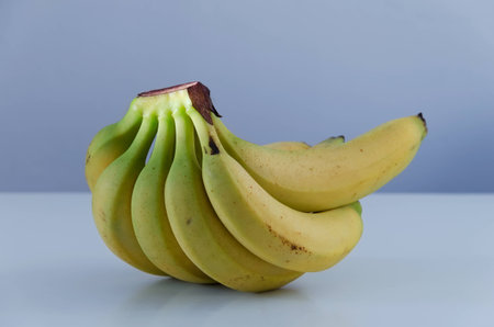 Close up of multiple bananas on bluish tableの写真素材