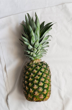 Single pineapple over white cloth, above viewの写真素材