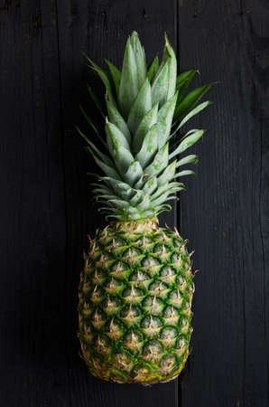 Single pineapple over black wooden tableの写真素材