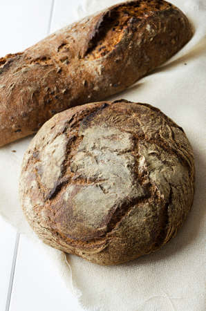 Traditional breads on white cloth over wooden table, above viewの写真素材