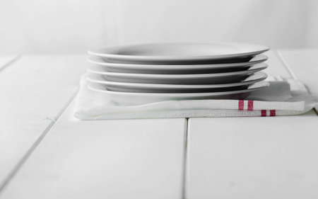 Empty stack of dishes over white wooden tableの写真素材