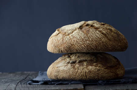 Traditional round bread over dark wooden tableの写真素材