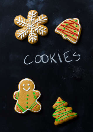 Homemade gingerbread cookies over black chalkboard, above viewの写真素材