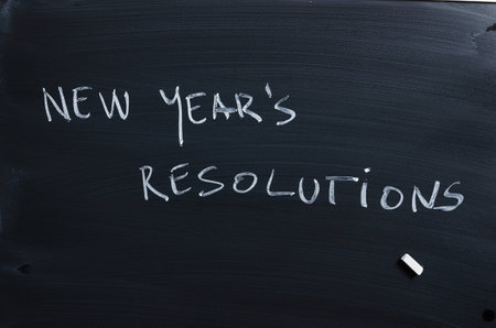 Handwritten word: New Year's Resolutions over black chalkboard