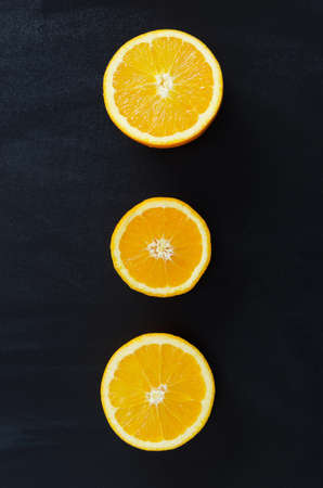 Orange fruits over black chalkboard with handwritten oranges word , above view