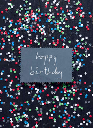 Handwritten card with "happy birthday " text over black wooden tableの写真素材