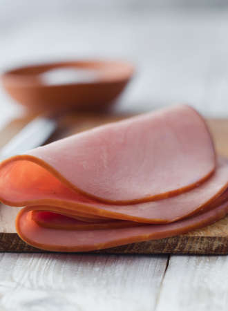 Close up of a pork ham slices over white wooden tableの写真素材