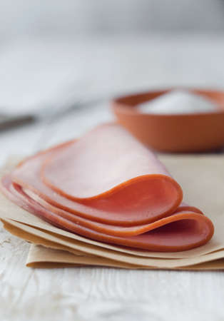 Close up of a pork ham slices over white wooden tableの写真素材
