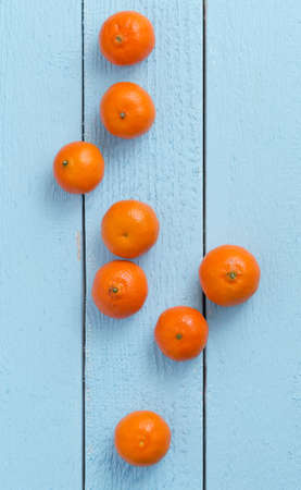Multiple clementines over blue wooden table, top viewの写真素材