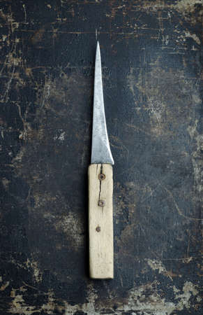 Vintage knife over dark grunge background, top viewの写真素材