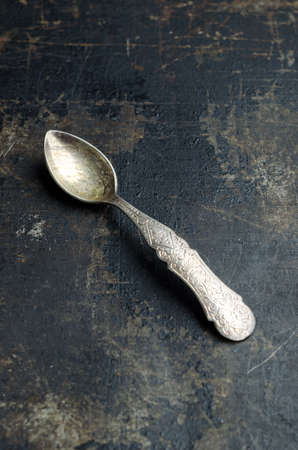 Close up of a teaspoon over dark grunge backgroundの写真素材