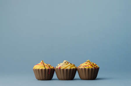 Three Chocolate Cup Cake over blue backgroundの写真素材