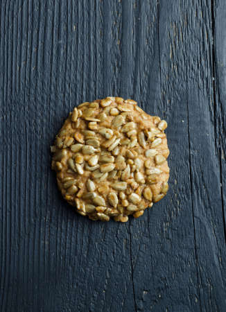 Homemade cookie with sunflower seeds over black wooden table, top viewの写真素材