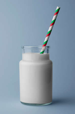 Single glass of milk over blue backgroundの写真素材