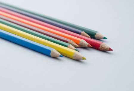 Close up of wooden colored crayons over blue background