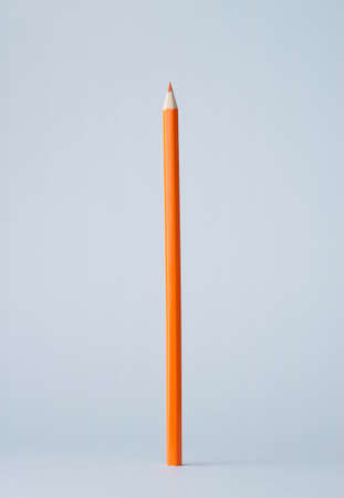 Wooden colored crayon standing over blue backgroundの写真素材