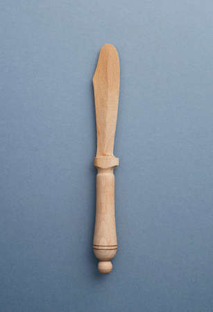 Wooden knife butter over blue background, above view