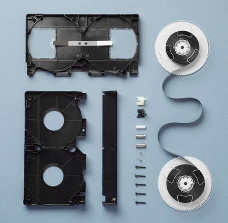 Components of a VHS Cassette disassembled and well arranged over blue backgroundの写真素材