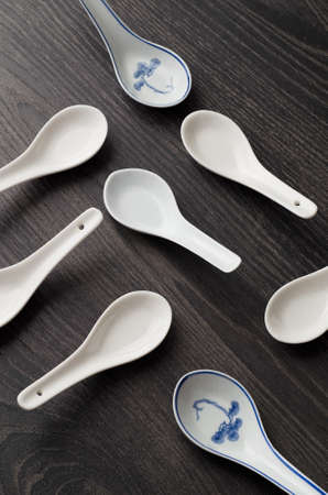 Collection chinese soup spoons over dark wooden tableの写真素材
