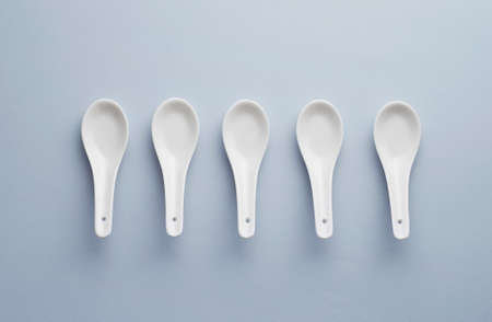 Collection of chinese soup spoons over blue background, above viewの写真素材