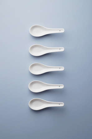 Collection of chinese soup spoons over blue background, above viewの写真素材