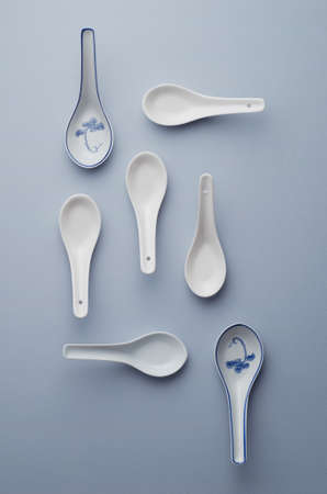 Collection of chinese soup spoons over blue background, above viewの写真素材