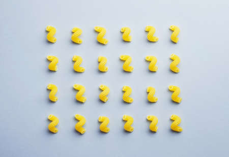 Raw macaroni organized over blue background, above view