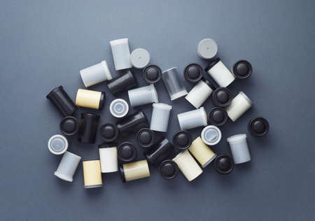 Photo film rolls disorganized over dark blue background, above view