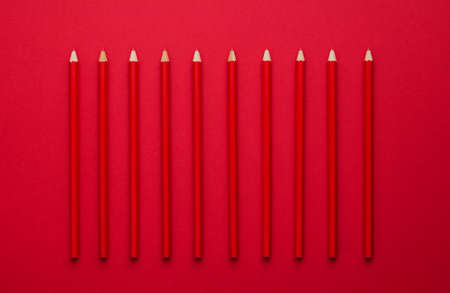 Red crayons organized in a row over red background, above viewの写真素材
